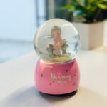 ⁦كرة ثلج بلورة بتصميم بنت بداخلها لون زهري⁩ - الصورة ⁦2⁩