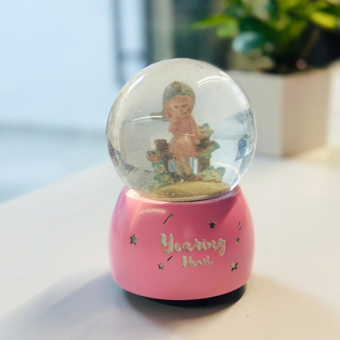 ⁦كرة ثلج بلورة بتصميم بنت بداخلها لون زهري⁩ - الصورة ⁦2⁩