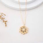 سلسال ذهبي بتصميم ندفة ثلج مع إطار بأحجار زركون أبيض و أزرق