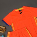 طقم رياضي (تيشيرت وشورت) للأطفال لون برتقالي وأصفر