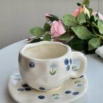 فنجان مع صحن لون أبيض مورد أزرق