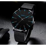 ساعة يد دائرية رجالية كوارتز فخمة - حزام شبكي أنيق - من الستانلس ستيل- ماركة Geneva - لون أسود مع عقارب باللون الأزرق