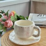 فنجان مع صحن لون أبيض بتصميم ببيونة