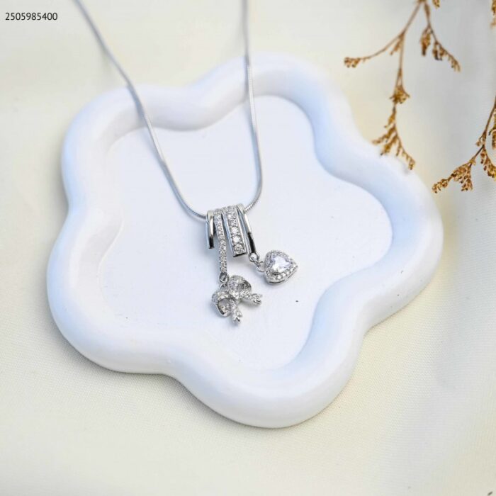 103385066_685eccc002afc سلسال بتصميم قلب مع فيونكة لون فضي - الصورة 1