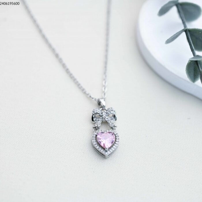 103385121_685ecd354bd91 سلسال شكل ببيونة مع قلب حجر (اللون: فضي وزهري ) - الصورة 1