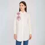 قميص لون أبيض تطريز أزرق وزهري من الأمام والخلف على الكتف