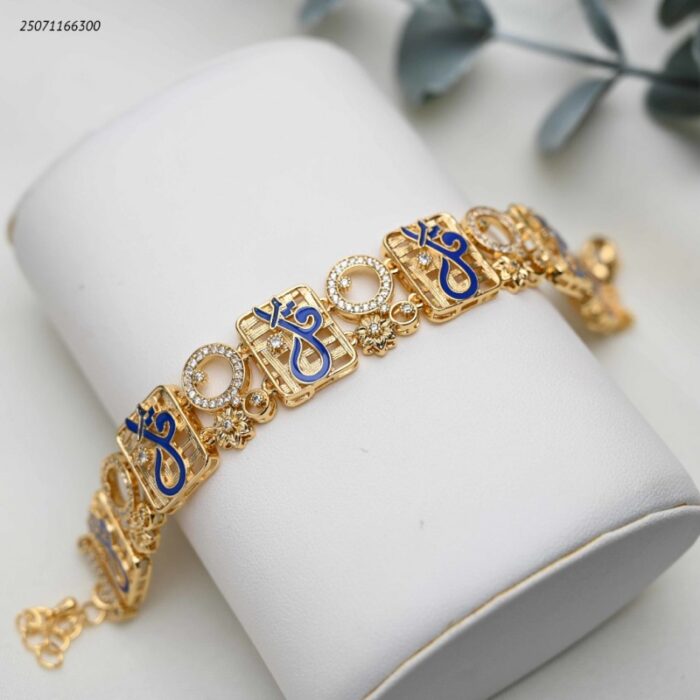 103391834_68e2e699a55ad سوار عريضة عبارة عن قطع مربعة متشابكة مع زركون و كتابة بخط كحلي كلمة قل لون ذهبي - الصورة 1