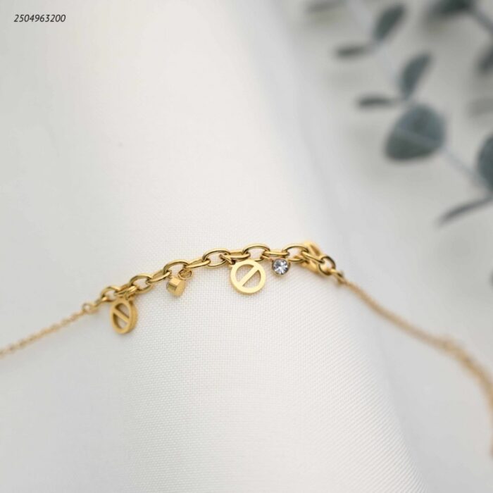 103391947_68e2e6eb586f4 سوار جنزير مع تعليقات ماركة لون ذهبي - الصورة 1