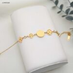 سوار ماركة+ تتميز بتصميم يجمع بين أربعة رموز مميزة لون ذهبي