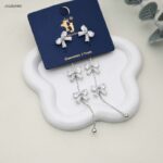 حلق متدلي مزين بثلاثة فيونكات مرصعة لون فضي