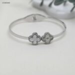 سوار عريض مزين بورقتي برسيم لون فضي وابيض