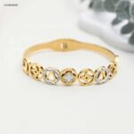 سوار ذهبي عريض مزين بخمسة أشكال متصلة لون ذهبي