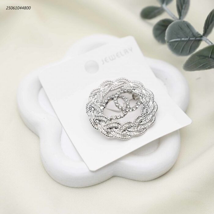 103392193_68e2e78f70ad3 بروش شكل ماركة مع زركون لون فضي - الصورة 1