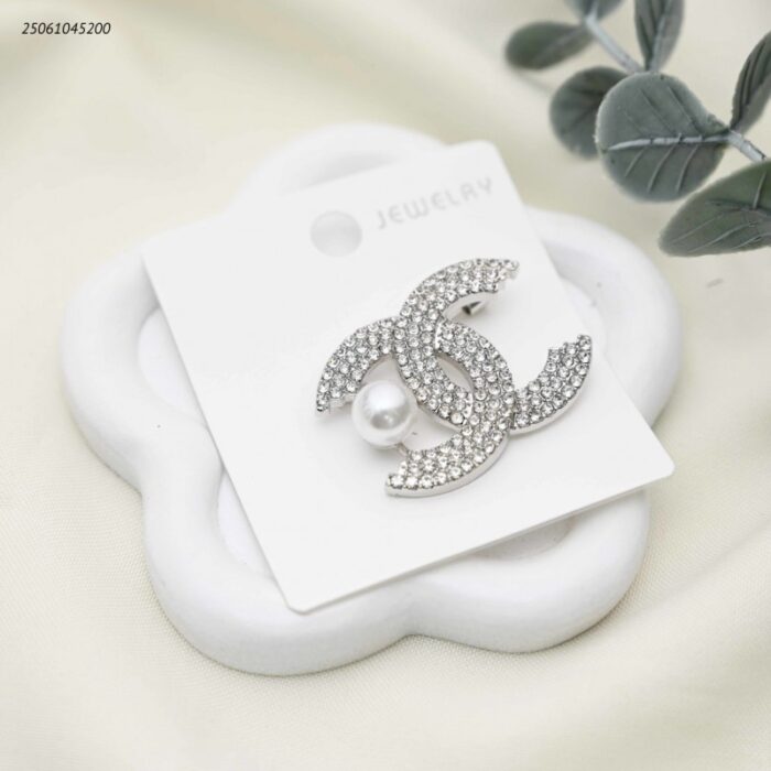 103392196_68e2e7956aa81 بروش شكل ماركة مع زركون لون فضي - الصورة 1