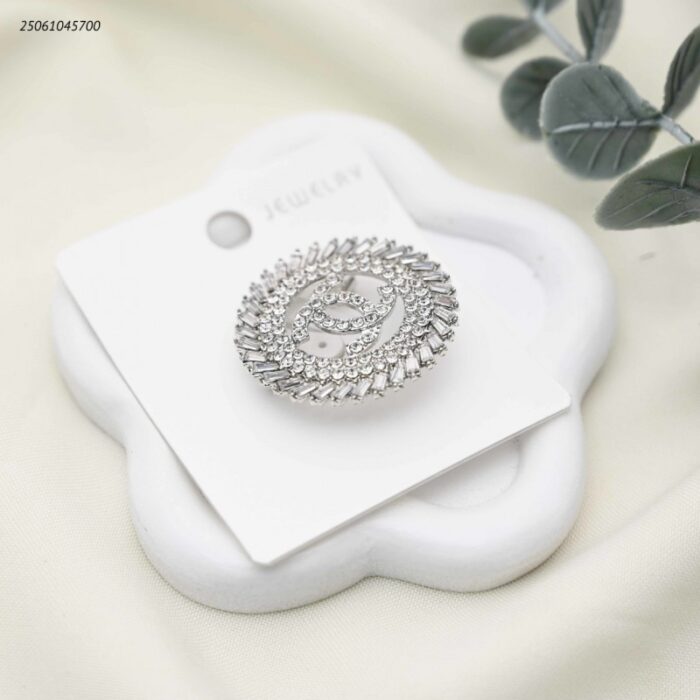 103392200_68e2e79b2ab64 بروش شكل ماركة مع زركون لون فضي - الصورة 1