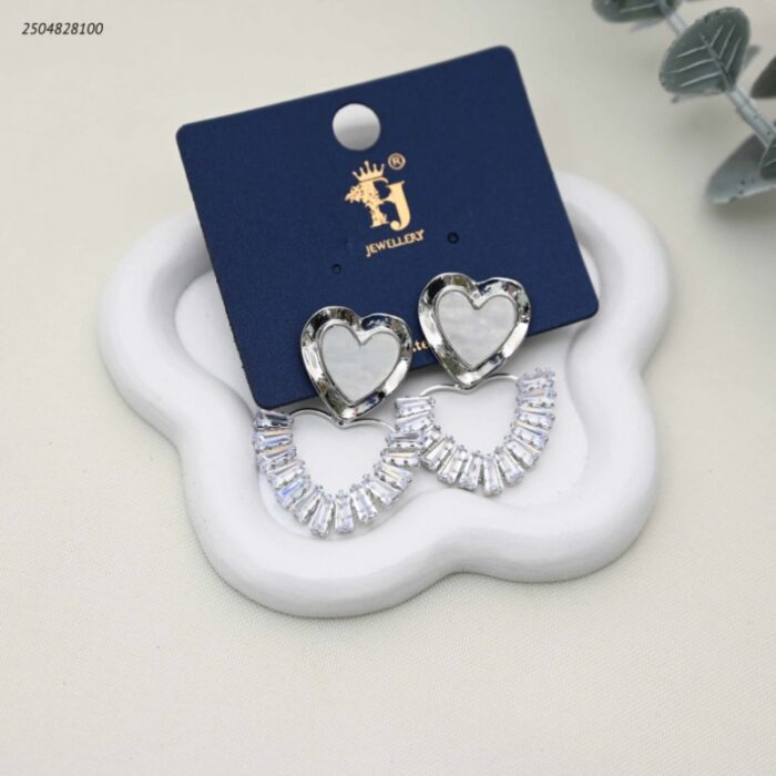 103392227_68e2e7b631cb1 حلق نسائي بتصميم قلبين قلب بلون اللؤلؤ وقلب مرصع بالزيركون لون فضي - الصورة 1