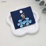 حلق نسائي بتصميم زهرة مطلية بالمينا الفيروزية ومرصعة بالكريستال لون فضي