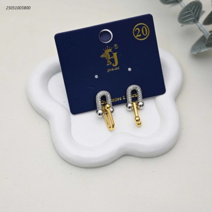 103392243_68e2e7edb54e0 حلق أنيق بتصميم حدوة حصان بلونين ومرصعة بالزركون لون فضي و ذهبي - الصورة 1