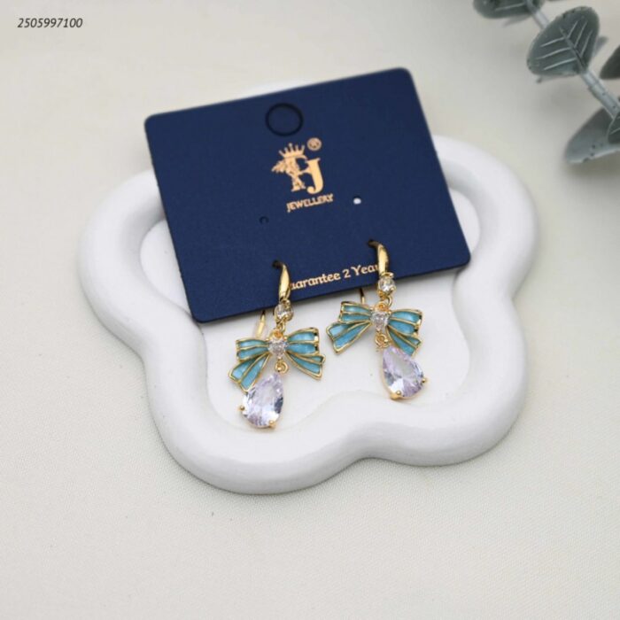 103392246_68e2e7f29384a حلق أذن متدلي بتصميم فيونكة وكريستال على شكل دمعة لون ذهبي - الصورة 1