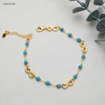 خلخال مع خرز بلون أزرق و شكل انفنتي لون ذهبي