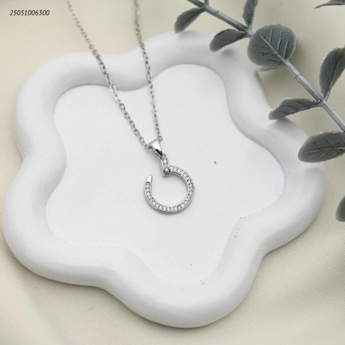 103392308_68e2e824584d7 سلسال عصري بتصميم مسمار دائري مرصع بالزركون لون فضي - الصورة 1