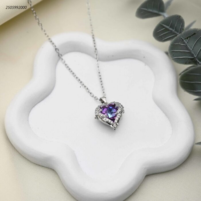 103392317_68e2e831e5a6a سلسال بتعليقة قلب أزرق مجنح مرصعة بالكريستال لون فضي - الصورة 1