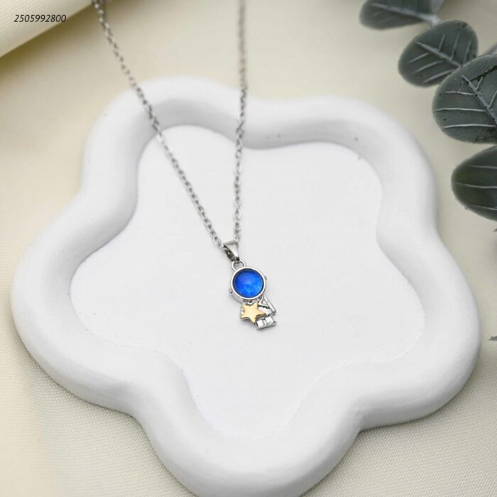 103392319_68e2e834616c6 سلسال بتعليقة رائد فضاء وزجاج أزرق ونجمة ذهبية لون فضي - الصورة 1