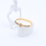 سوار لون ذهبي مع احجار زركون أبيض بتصميم وردة