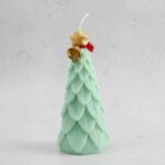 شمعة كريسماس معطرة على شكل شجرة حجم وسط أخضر مع شبرة أحمر وجرس ذهبي