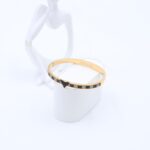 سوار لون ذهبي بتفاصيل جلد أسود ورماردي وزركون أسود