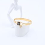 سوار لون ذهبي بتصميم قفل ونجمه مع تفاصيل أسود